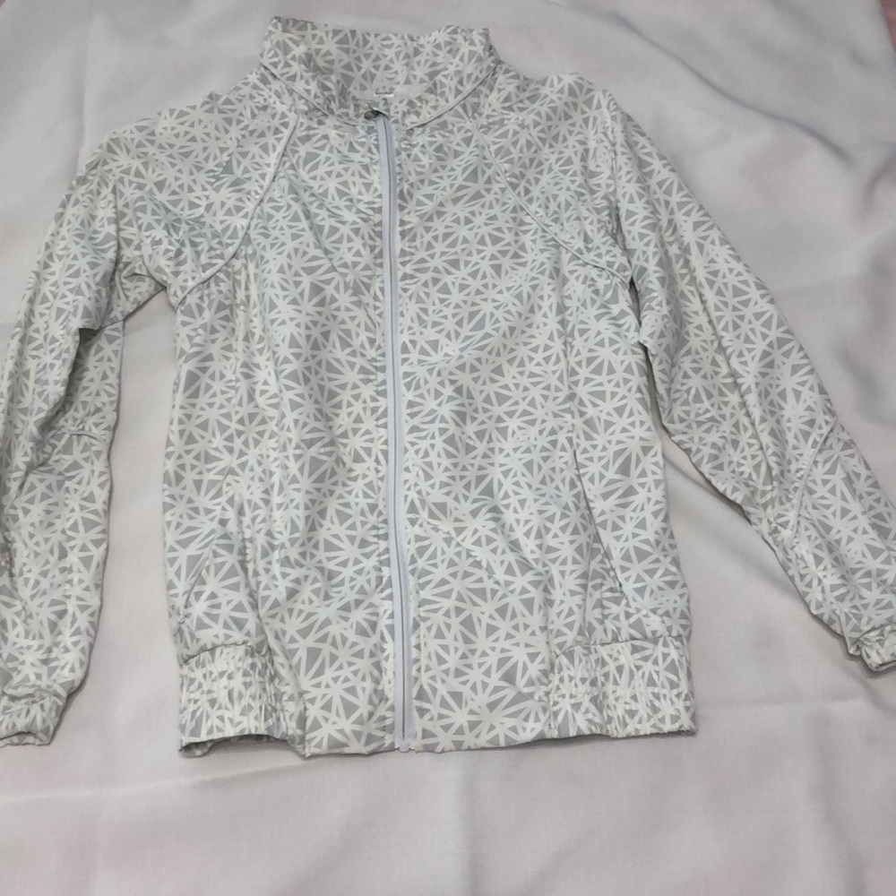 Grey and white geometric patterned wind breaker.